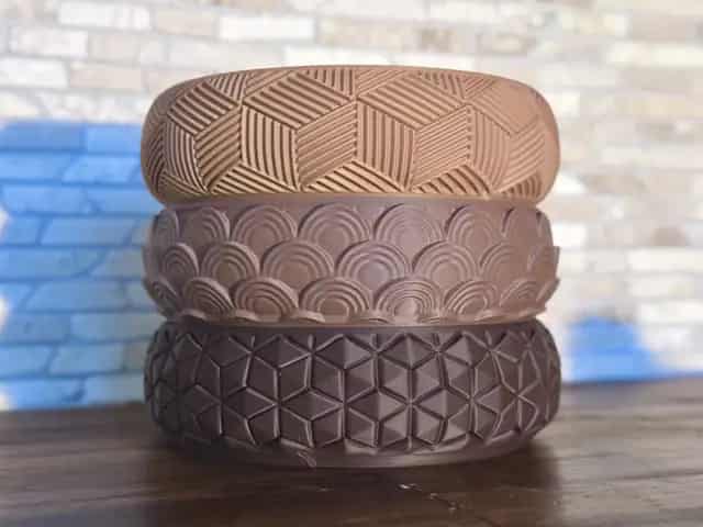 3D printed bowls on a dark studio surface.