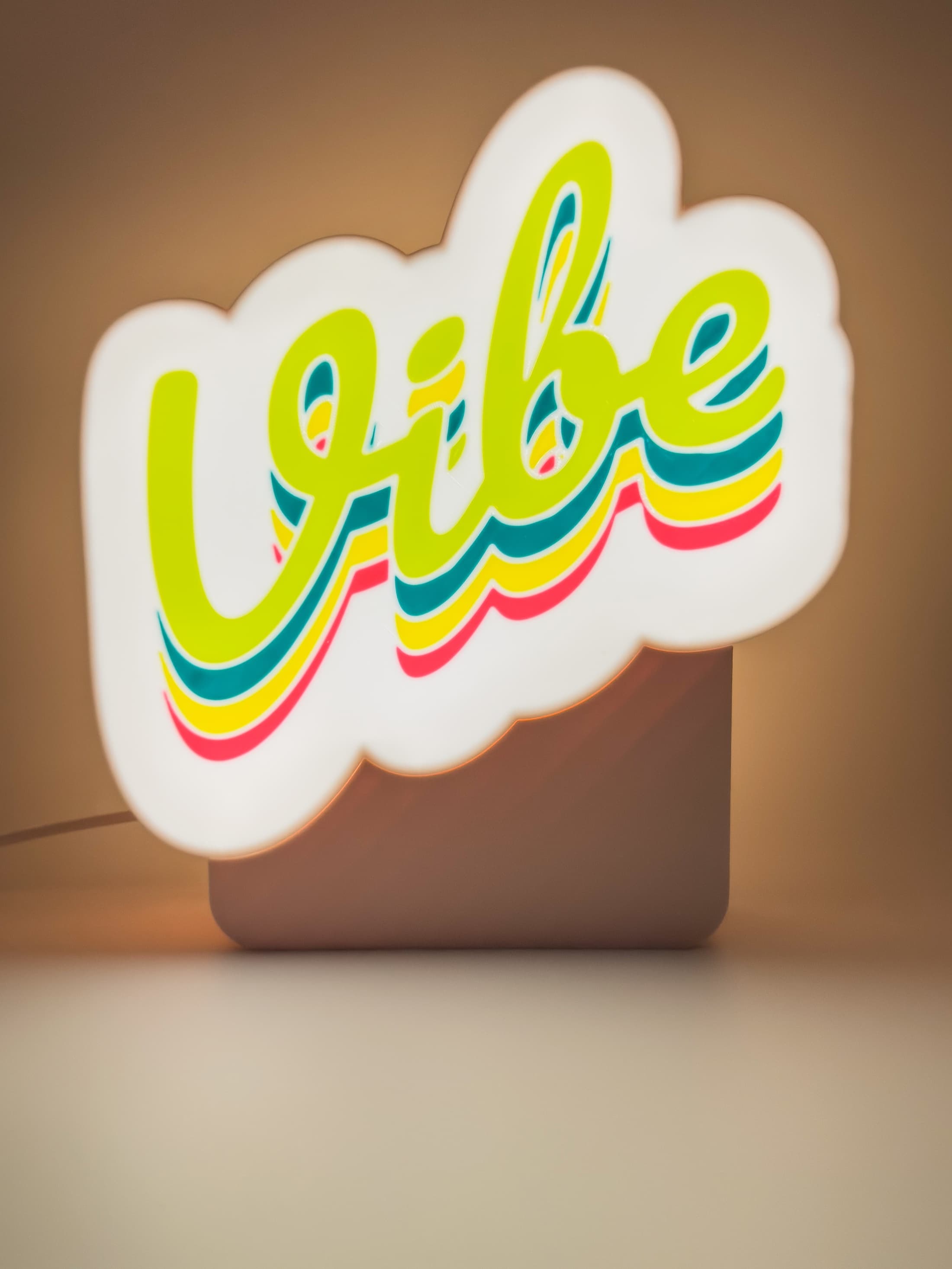 Warm illuminated custom logo lightbox on a soft studio background.