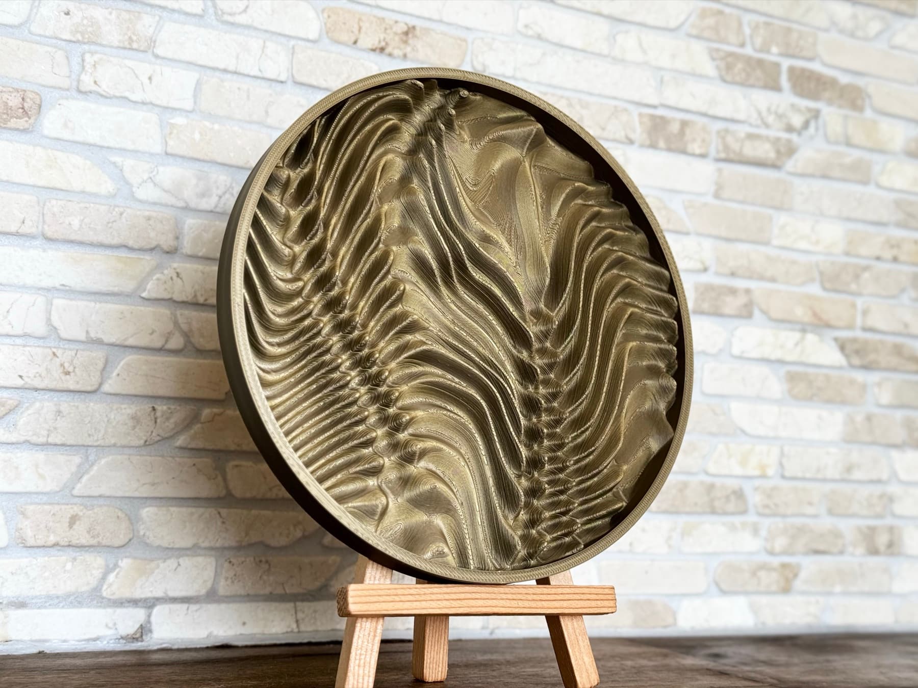 Relief coaster displayed on a small wooden easel.